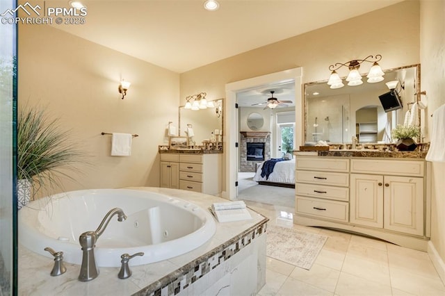 5085 Saxton Hollow Rd, Colorado Springs, CO 80908 - bathroom with two vanities, ceiling fan, a stone fireplace, a whirlpool tub, and connected bathroom