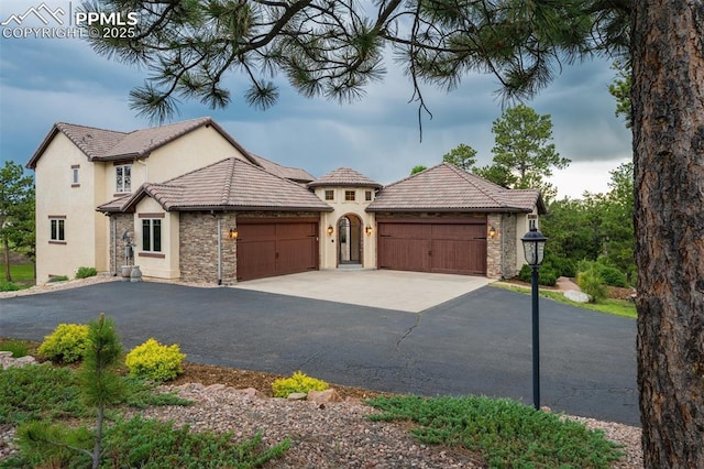 5085 Saxton Hollow Rd, Colorado Springs, CO 80908 - view of front of property with a garage, driveway, stucco siding, and stone siding