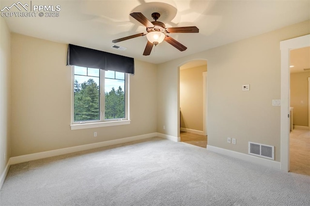 5085 Saxton Hollow Rd, Colorado Springs, CO 80908 - empty room with arched walkways, ceiling fan, and light colored carpet