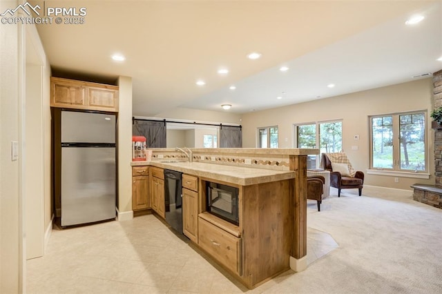 5085 Saxton Hollow Rd, Colorado Springs, CO 80908 - kitchen with black appliances, a peninsula, recessed lighting, open floor plan, and light countertops