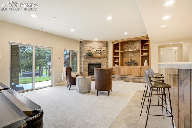5085 Saxton Hollow Rd, Colorado Springs, CO 80908 - living area with a stone fireplace, recessed lighting, built in shelves, and light colored carpet