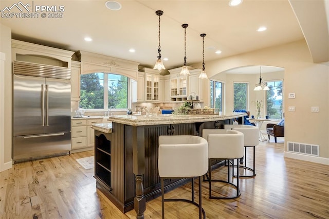 5085 Saxton Hollow Rd, Colorado Springs, CO 80908 - kitchen with built in refrigerator, open shelves, a breakfast bar area, healthy amount of natural light, and recessed lighting