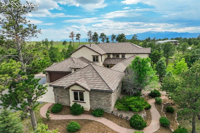 5085 Saxton Hollow Rd, Colorado Springs, CO 80908 - view of front of property featuring stone siding, stucco siding, an attached garage, and a mountain view