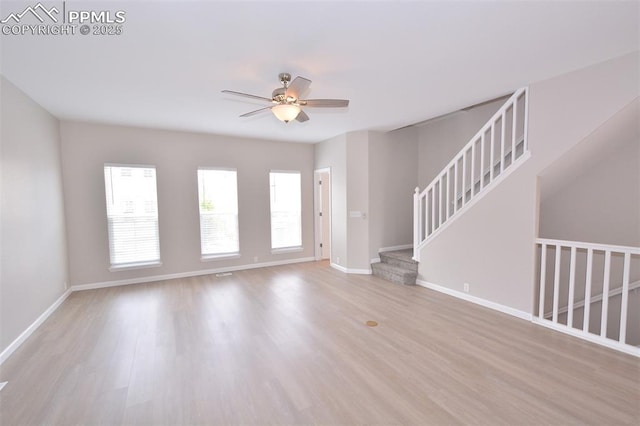 1160 Walters Pt, Monument, CO 80132 - unfurnished living room featuring ceiling fan, wood finished floors, baseboards, and stairs