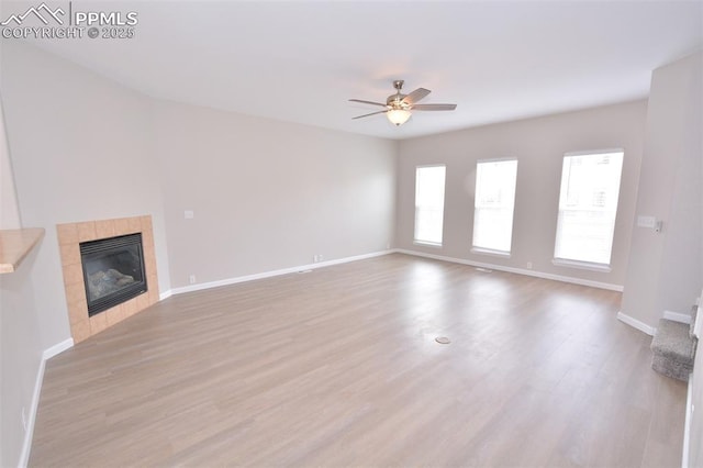 1160 Walters Pt, Monument, CO 80132 - unfurnished living room with ceiling fan, wood finished floors, baseboards, and a tiled fireplace