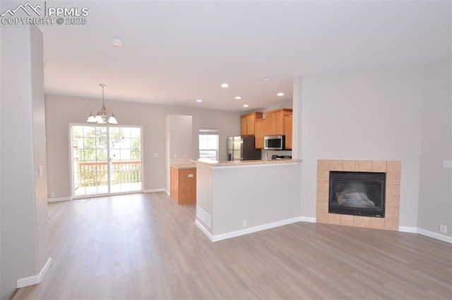 1160 Walters Pt, Monument, CO 80132 - unfurnished living room featuring light wood-style flooring, recessed lighting, baseboards, a tile fireplace, and a chandelier