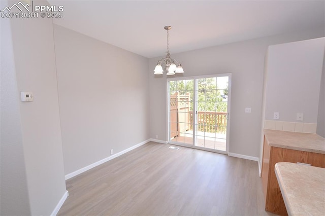 1160 Walters Pt, Monument, CO 80132 - unfurnished dining area with light wood finished floors, baseboards, and a chandelier