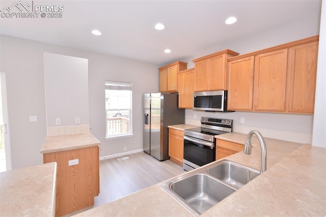 1160 Walters Pt, Monument, CO 80132 - kitchen featuring stainless steel appliances, a sink, light wood-type flooring, light countertops, and recessed lighting