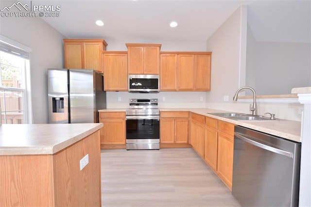 1160 Walters Pt, Monument, CO 80132 - kitchen with stainless steel appliances, a sink, light brown cabinets, light wood-style floors, and light countertops