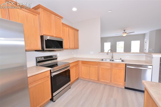 1160 Walters Pt, Monument, CO 80132 - kitchen featuring stainless steel appliances, a sink, light brown cabinets, a peninsula, and light countertops