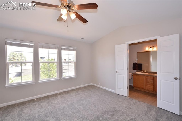 1160 Walters Pt, Monument, CO 80132 - unfurnished bedroom featuring a sink, lofted ceiling, light colored carpet, multiple windows, and baseboards