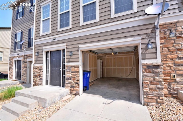 1160 Walters Pt, Monument, CO 80132 - doorway to property with stone siding, a garage, and driveway