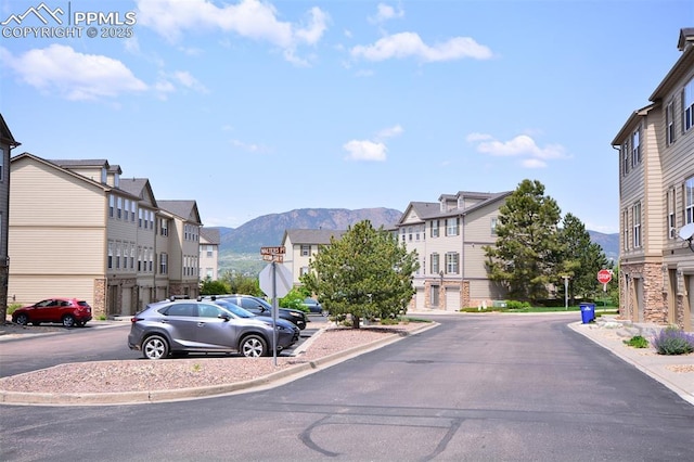 1160 Walters Pt, Monument, CO 80132 - view of asphalt street featuring traffic signs, a residential view, a mountain view, and curbs