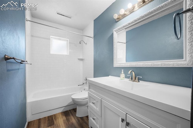 305 Rosewood Dr, Fountain, CO 80817 - full bath with vanity, toilet, wood finished floors, shower / bath combination, and a textured wall