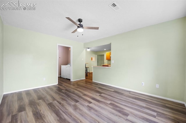 305 Rosewood Dr, Fountain, CO 80817 - unfurnished living room with washer and clothes dryer, ceiling fan, dark wood-type flooring, baseboards, and a textured ceiling