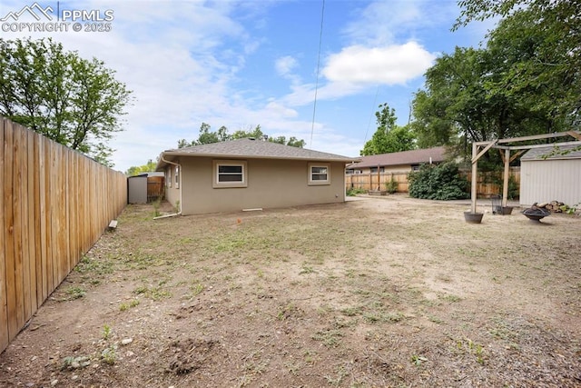 305 Rosewood Dr, Fountain, CO 80817 - fenced backyard with an outdoor fire pit and a storage unit