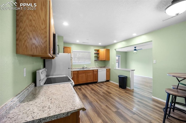 305 Rosewood Dr, Fountain, CO 80817 - kitchen featuring white appliances, a sink, brown cabinets, dark wood-type flooring, and a ceiling fan