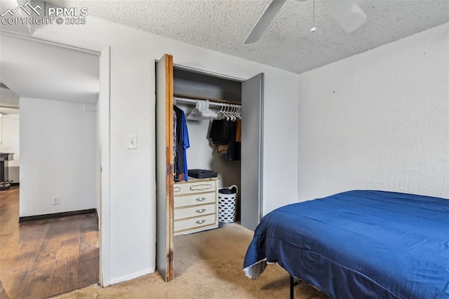 2123 Kodiak Dr, Colorado Springs, CO 80910 - bedroom featuring a textured ceiling, ceiling fan, a closet, baseboards, and wood finished floors