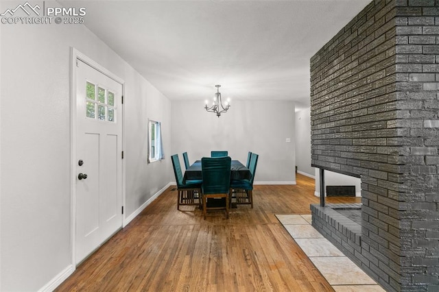 1513 Rosemont Dr, Colorado Springs, CO 80911 - dining space featuring hardwood / wood-style flooring, a chandelier, baseboards, and a fireplace