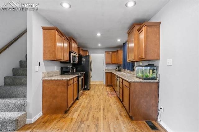 1513 Rosemont Dr, Colorado Springs, CO 80911 - kitchen featuring stainless steel appliances, a sink, light wood finished floors, brown cabinets, and recessed lighting