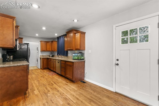1513 Rosemont Dr, Colorado Springs, CO 80911 - kitchen featuring brown cabinetry, baseboards, light wood-style flooring, recessed lighting, and washer / dryer