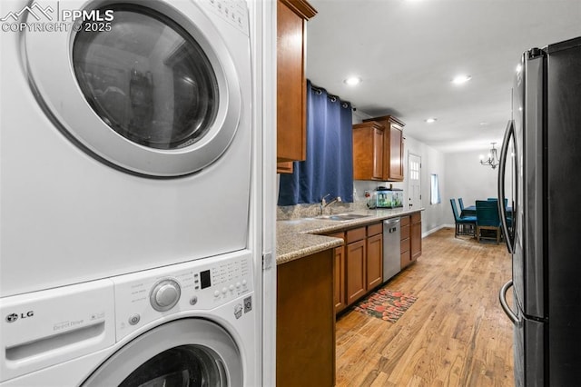 1513 Rosemont Dr, Colorado Springs, CO 80911 - washroom with stacked washer / dryer, a sink, light wood-type flooring, and recessed lighting