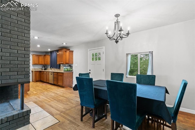 1513 Rosemont Dr, Colorado Springs, CO 80911 - dining area with a chandelier, light wood-style flooring, recessed lighting, a fireplace, and baseboards