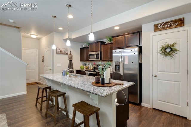 2001 Birmingham Loop, Colorado Springs, CO 80910 - kitchen with stainless steel appliances, a sink, dark wood-type flooring, dark brown cabinetry, and a kitchen bar