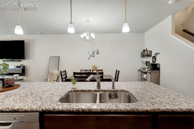 2001 Birmingham Loop, Colorado Springs, CO 80910 - kitchen featuring a sink, stainless steel dishwasher, light stone counters, hanging light fixtures, and open floor plan