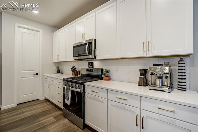 6950 Hidden Cove Ct, Castle Pines, CO 80108 - kitchen with stainless steel appliances, tasteful backsplash, white cabinets, dark wood-type flooring, and light countertops
