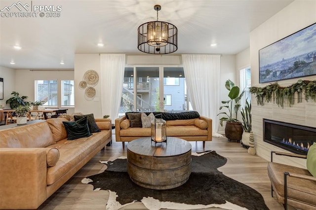 6950 Hidden Cove Ct, Castle Pines, CO 80108 - living room featuring a chandelier, wood finished floors, a tile fireplace, healthy amount of natural light, and recessed lighting