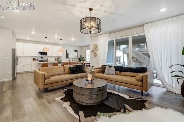 6950 Hidden Cove Ct, Castle Pines, CO 80108 - living area with light wood-style flooring, a chandelier, recessed lighting, and baseboards