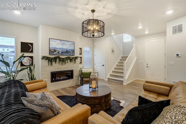 6950 Hidden Cove Ct, Castle Pines, CO 80108 - living room with stairway, wood finished floors, a chandelier, a fireplace, and baseboards