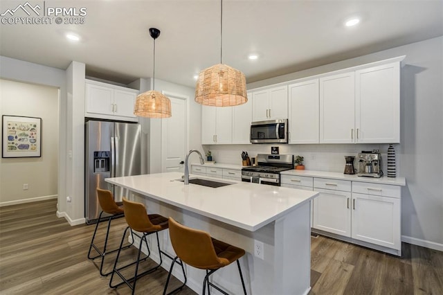 6950 Hidden Cove Ct, Castle Pines, CO 80108 - kitchen with appliances with stainless steel finishes, a sink, baseboards, a kitchen breakfast bar, and recessed lighting