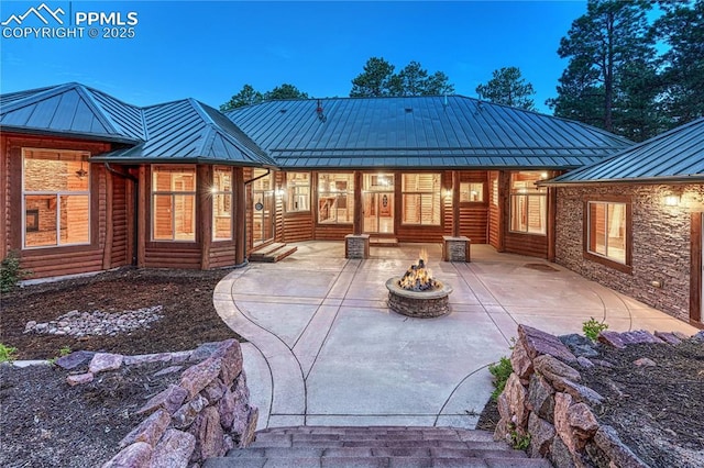 15975 Winding Trail Rd, Colorado Springs, CO 80908 - rear view of house featuring a standing seam roof, an outdoor fire pit, a metal roof, and a patio area