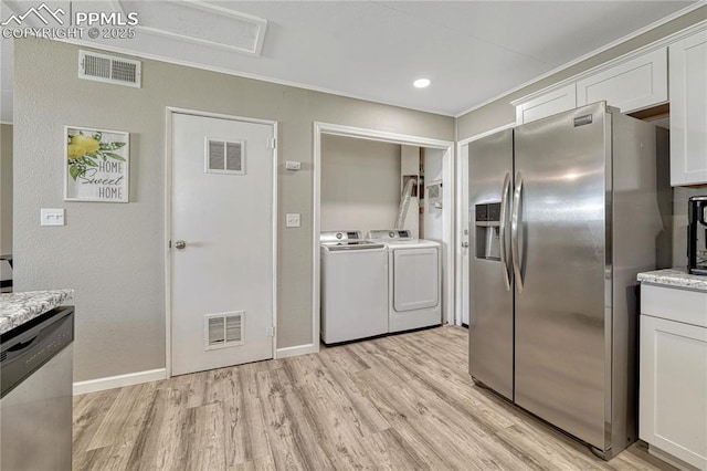 1917 S Institute Ave, Colorado Springs, CO 80905 - kitchen featuring stainless steel appliances, washer and clothes dryer, light wood finished floors, and white cabinets