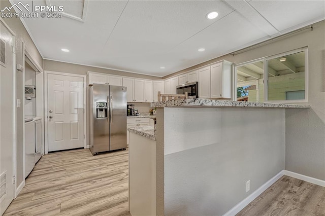 1917 S Institute Ave, Colorado Springs, CO 80905 - kitchen with appliances with stainless steel finishes, separate washer and dryer, light wood finished floors, white cabinetry, and light stone countertops