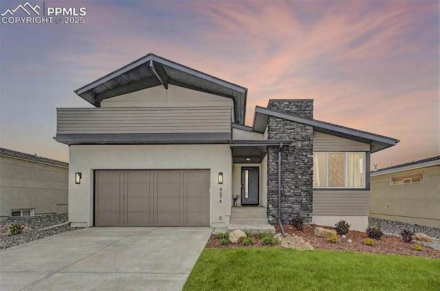 9276 Glitter Way, Colorado Springs, CO 80924 - contemporary house featuring concrete driveway, a garage, a front lawn, and stucco siding