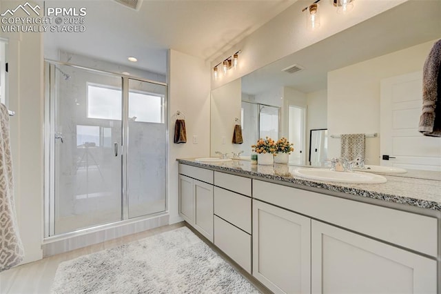 9276 Glitter Way, Colorado Springs, CO 80924 - full bath featuring double vanity, a shower stall, and wood finished floors
