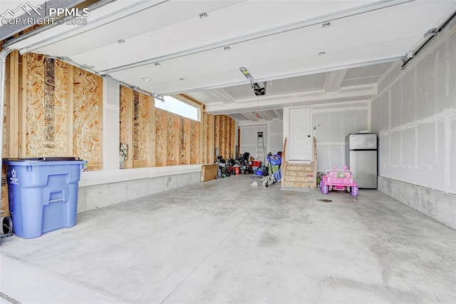 9276 Glitter Way, Colorado Springs, CO 80924 - garage featuring freestanding refrigerator and a garage door opener