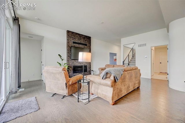 9276 Glitter Way, Colorado Springs, CO 80924 - living area featuring wood finished floors, stairway, a stone fireplace, and baseboards