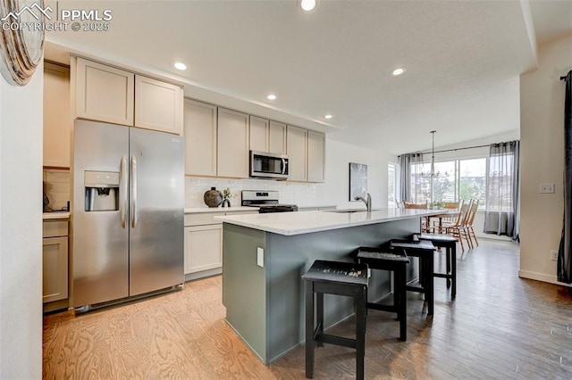 9276 Glitter Way, Colorado Springs, CO 80924 - kitchen with appliances with stainless steel finishes, a sink, tasteful backsplash, light wood-type flooring, and recessed lighting