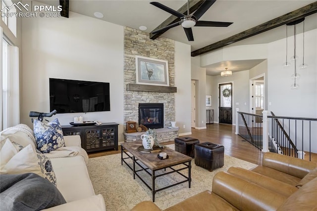 11598 Silver Charm Way, Colorado Springs, CO 80921 - living area with beamed ceiling, wood finished floors, a ceiling fan, a fireplace, and a high ceiling
