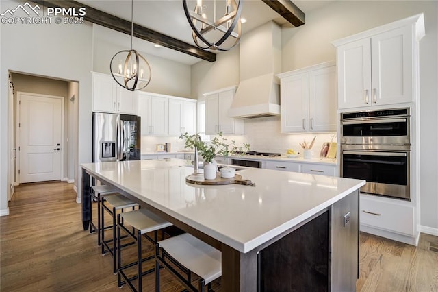 11598 Silver Charm Way, Colorado Springs, CO 80921 - kitchen with a chandelier, stainless steel appliances, a towering ceiling, beam ceiling, and custom exhaust hood