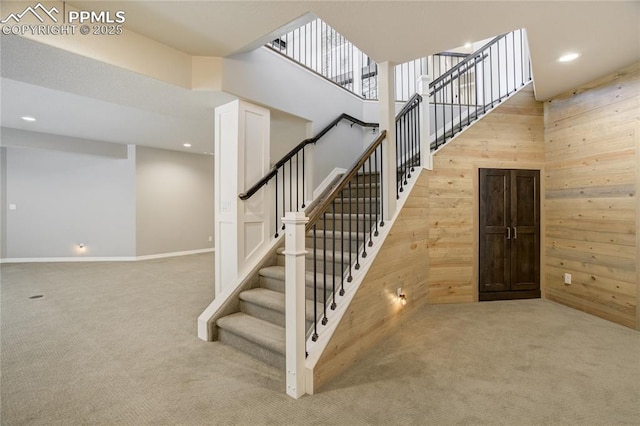 11598 Silver Charm Way, Colorado Springs, CO 80921 - staircase with carpet floors, wood walls, a towering ceiling, and recessed lighting