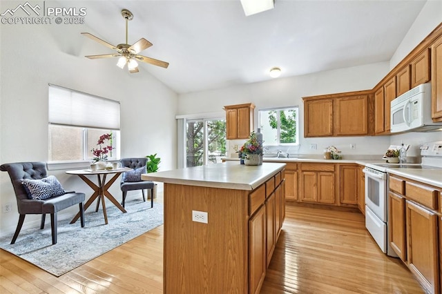 1646 Pinon Glen Cir, Colorado Springs, CO 80919 - kitchen with white appliances, light wood-type flooring, light countertops, a kitchen island, and vaulted ceiling