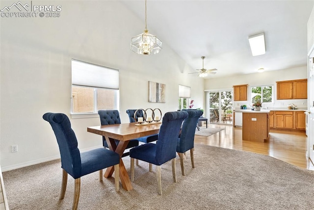 1646 Pinon Glen Cir, Colorado Springs, CO 80919 - dining area with light carpet, a ceiling fan, a chandelier, baseboards, and high vaulted ceiling