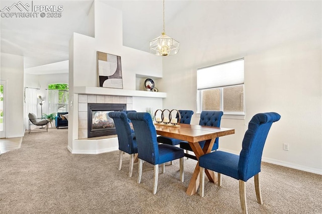 1646 Pinon Glen Cir, Colorado Springs, CO 80919 - carpeted dining area featuring a fireplace, baseboards, high vaulted ceiling, and a chandelier