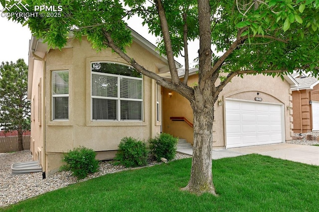 1646 Pinon Glen Cir, Colorado Springs, CO 80919 - view of front of property featuring driveway, stucco siding, a front lawn, and an attached garage
