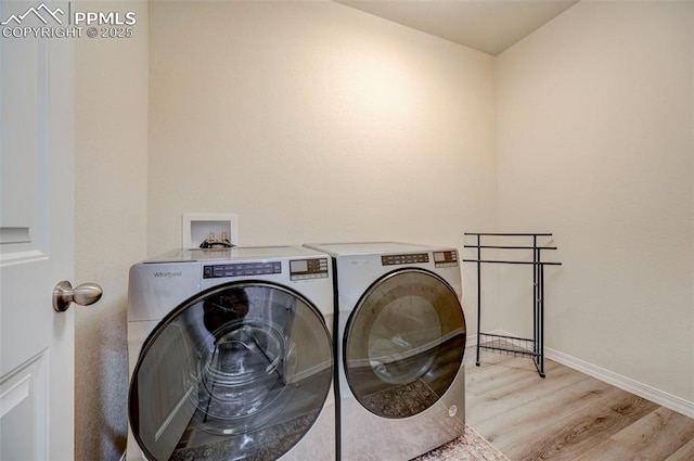 10806 Rolling Peaks Dr, Peyton, CO 80831 - laundry room with washer and dryer, light wood finished floors, and baseboards